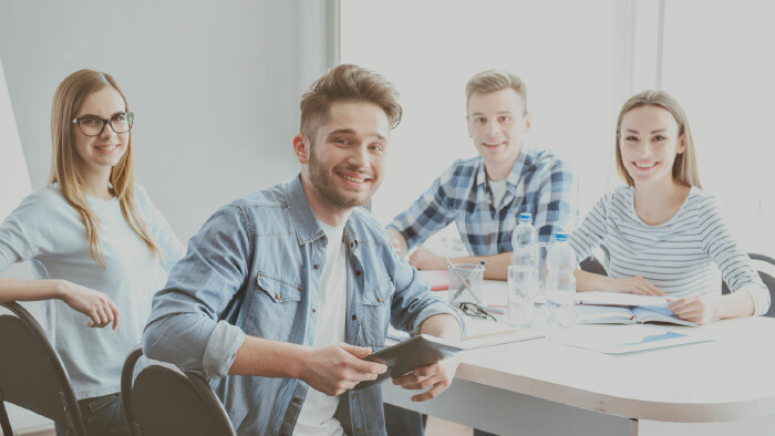 © Viacheslav Iakobchuk , stock.adobe.com 2 Mädchen und 2 Burschen sitzen an einem Tisch und nehmen an einem Coaching teil.