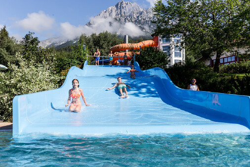 Kinder auf einer breiten Wasserrutsche im Kaiserbad Ellmau