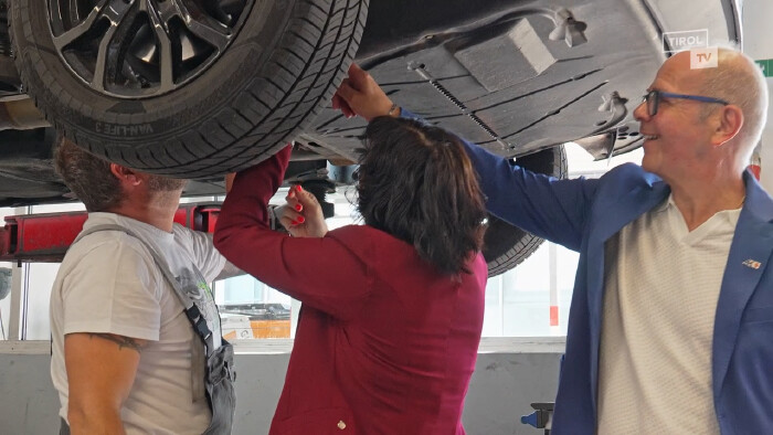 AK Vizepr&auml;sidentin Andrea Ager und Thomas Lintner helfen in der Karosserie-Werkstatt mit, hier im Bild beim Reparieren unter einem Auto