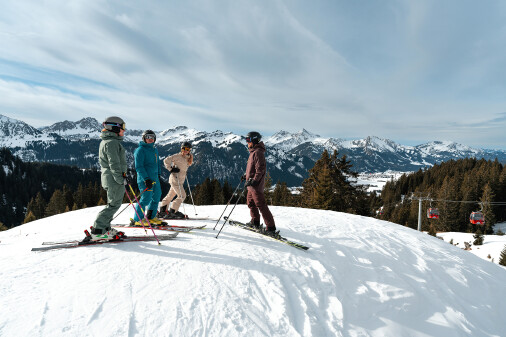 Mehrere Personen treffen sich auf der Skipiste in Skikleidung zum Austausch