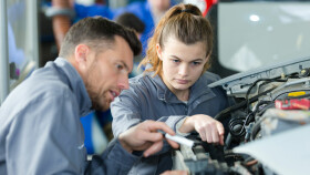 Lehrling bekommt von Ausbilder Einschulung am Fahrzeug