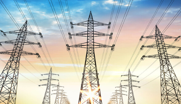 Drei Reihen von knapp hintereinander stehenden Strommasten, das Bild scheint KI zu sein