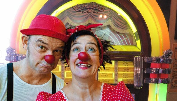 Die Clowns Herbert und Mimi vor einem Wurlitzer. 