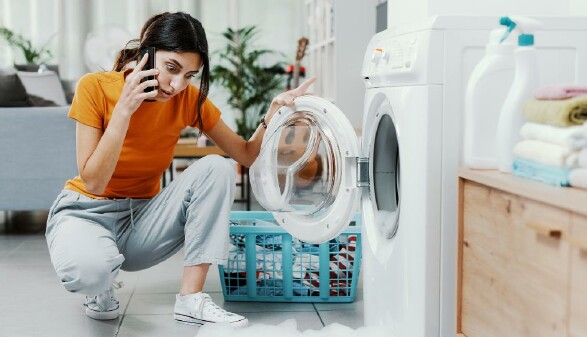 Frau ärgert sich über defekte Waschmaschine