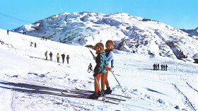 Zwei Skifahrer fahren mit dem Schlepplift in St. Anton am Arlberg auf den Berg hinauf