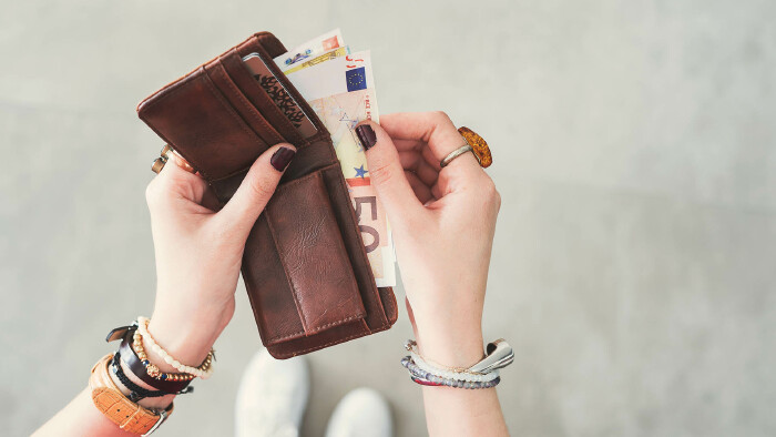 Frau nimmt Geld aus Geldtasche