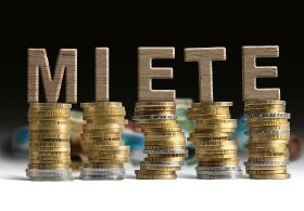 Buchstaben MIETE auf aufgestapelten Münzen