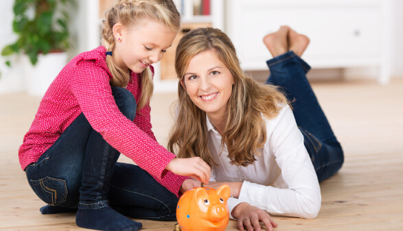 Mutter mit Tochter und Sparschwein