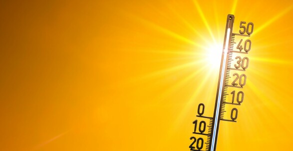 Die Sonne strahlt stark auf ein Thermometer, welches über 35 Grad Celsius anzeigt. © Canva
