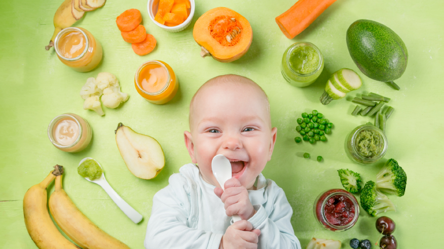 Kind mit Löffel in der Hand, Gemüse und Obst rundherum