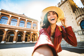 Frau mit Hut schie&szlig;t ein Selfie beim Sightseeing im Urlaub