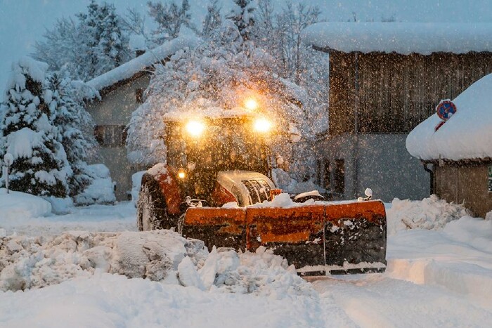 Traktor räumt den Schnee auf der Straße