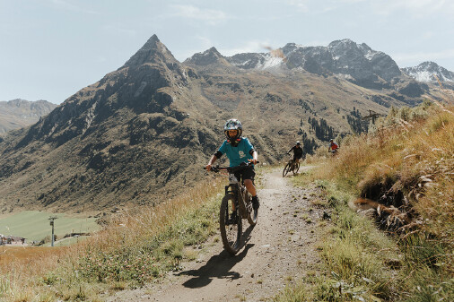 Mountainbiker fahren auf einem Weg in gebirgiger Landschaft