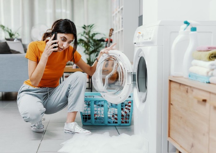 Frau ärgert sich über defekte Waschmaschine