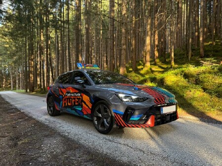 Ein Cupra der Fahrschule Laufer steht auf einem Weg im Wald
