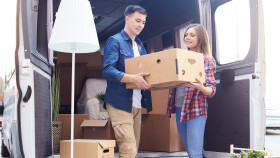 junges Paar entlädt Umzugskarton