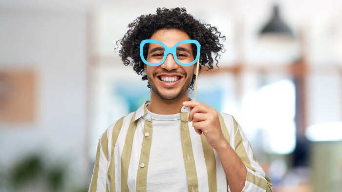 Junger Mann mit Faschingsmaske im Büro