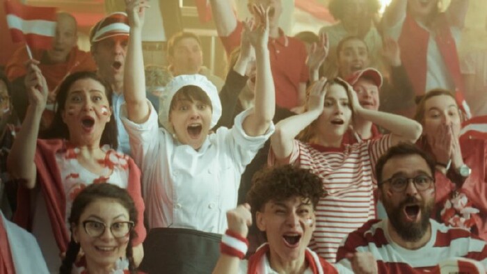 Eine Gruppe von &Ouml;sterreich-Fans auf einer Trib&uuml;ne beim Jubeln.