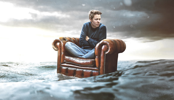 © lassedesignen/adobe.stock.com Mann auf Sessel treibt im Meer © lassedesignen/adobe.stock.com
