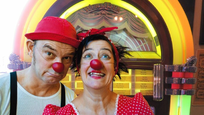 Die Clowns Herbert und Mimi vor einem Wurlitzer. 