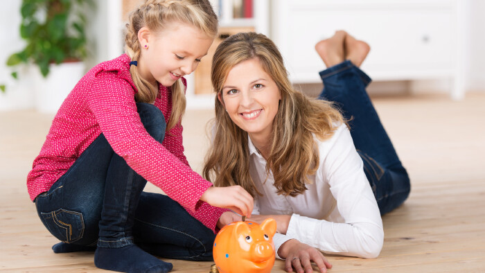 © contrastwerkstatt/stock.adobe.com Mutter mit Tochter und Sparschwein