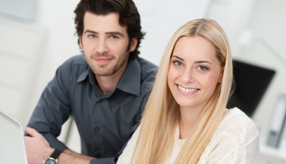 Mann und Frau sitzen vor Laptop