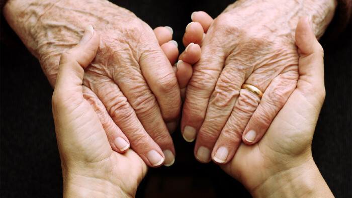 Jüngere Hand hält ältere Hand