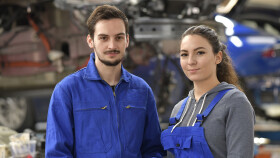 Weiblicher und männlicher Lehrling in Autowerkstatt