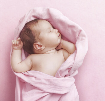 Baby liegt in einem rosa Tuch