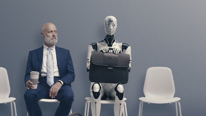 Ein älterer Herr und ein Roboter warten auf ihr Vorstellungsgespräch